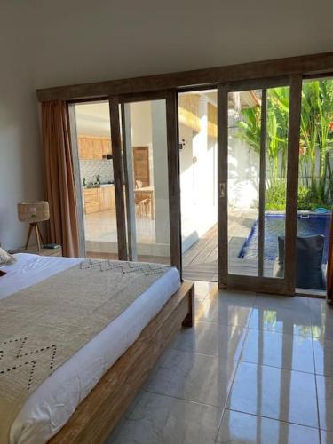 um quarto com uma cama e portas de vidro deslizantes em Villa Salamanca em Dalung