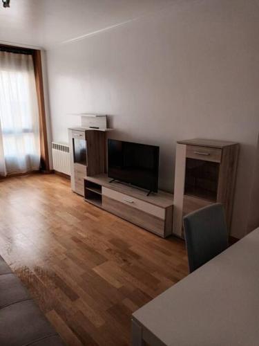 a living room with a flat screen tv and a wooden floor at Tu dulce hogar, apartamento completo,céntrico con wifi y parking gratuito in Vigo