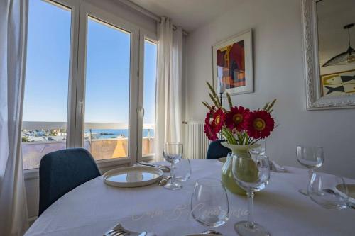 une table avec des verres à vin et un vase avec des fleurs dans l'établissement LE PHARE - 2 personnes à Concarneau, à Concarneau