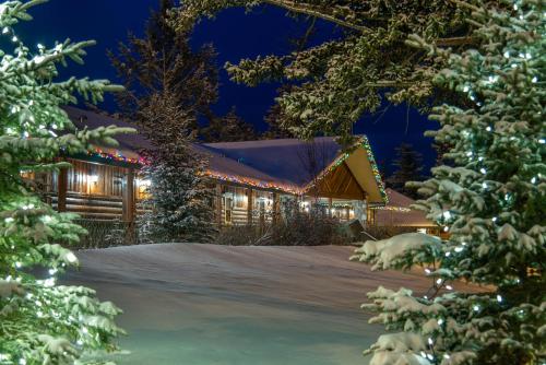 a house covered in christmas lights in the snow at Fairmont Jasper Park Lodge in Jasper