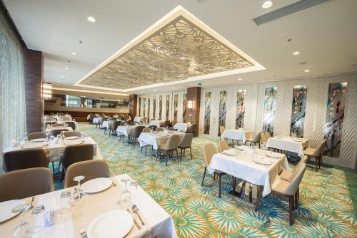 a restaurant with tables and chairs and a large ceiling at Ramada by Wyndham Gemli̇k in Gemlik