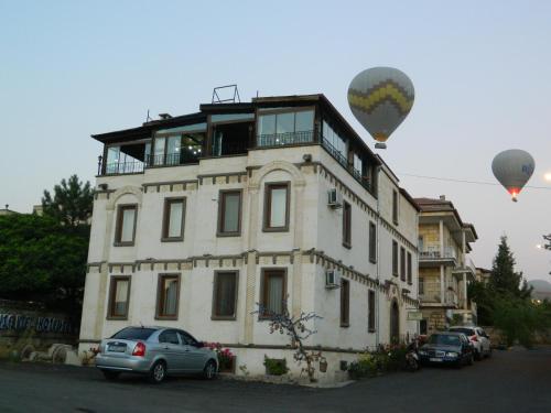 a building with two hot air balloons flying over it at Sun Rise View Hotel in Goreme