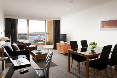a living room with a table and chairs at The Sebel Quay West Suites Sydney in Sydney