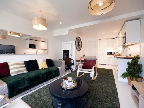 a living room with a green couch and a table at Luxury Haven with King Suites and Parking in London