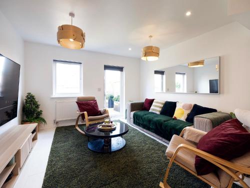 ein Wohnzimmer mit einem Sofa und einem Tisch in der Unterkunft Luxury Haven with King Suites and Parking in London