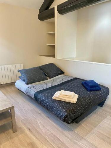une chambre avec un lit avec des draps et des oreillers bleus dans l'établissement Studio climatisé proche gare, à Bourg-en-Bresse