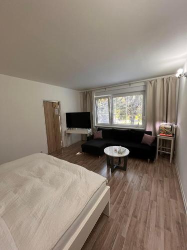 a bedroom with a bed and a living room at Luxury apartman L&A in Košice