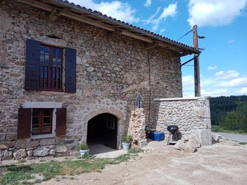 a large stone building with a door and a window at Les chambres de Solol in Félines