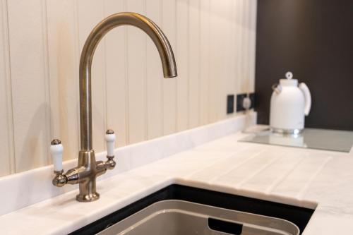 a kitchen sink with a faucet and two candles at Siabod - Snowdonia, North Wales in Bethesda