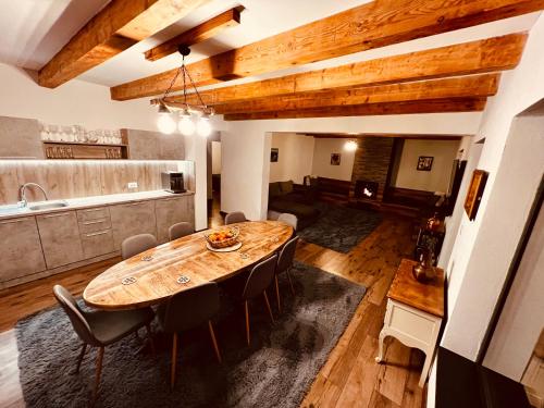 a kitchen and dining room with a wooden table and chairs at La Izvoare in Clopotiva