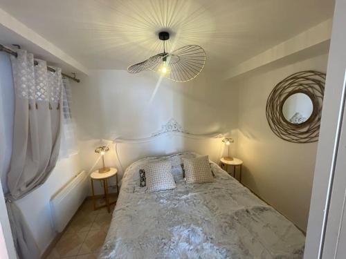 a bedroom with a bed with two tables and a fan at L’escapade Balnéo, Centre ville in Sens