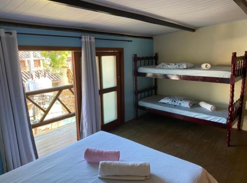 a bedroom with two bunk beds and a balcony at FLAT 2 QUARTOS PITUBA - ITACARÉ-Ba in Itacaré