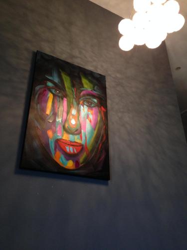 a painting of a clown hanging on a wall at Le Hameau de la Crique de l'Anglaise in Bandol