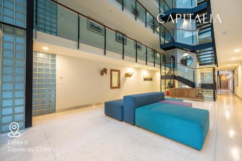 una sala de estar con un sofá azul en un edificio en Capitalia - Apartments - CÉFIRO CINCO en Ciudad de México
