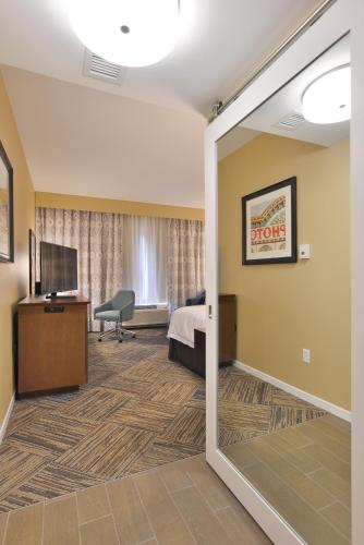a hotel room with a door leading to a bedroom at Hampton Inn & Suites Chippewa Falls in Chippewa Falls