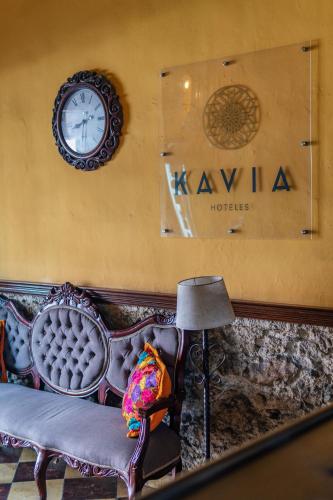 a room with a couch and a clock on the wall at Hotel Santiago in Mérida