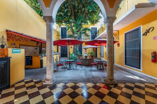 a courtyard with tables and umbrellas in a building at Hotel Santiago in Mérida