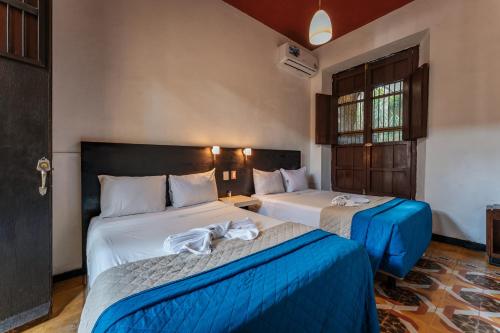 2 letti in camera d'albergo con asciugamani di Hotel Santiago a Mérida