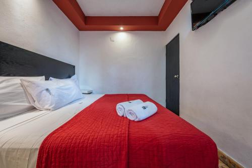 a bed with two towels sitting on top of it at Hotel Santiago in Mérida