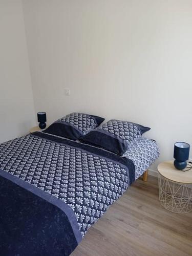 une chambre avec un lit avec des draps et des oreillers bleus dans l'établissement Nuit étoilée - Dormir Comme A La Maison, à Saint-Julien-de-Vouvantes