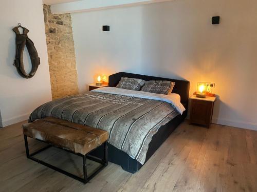 a bedroom with a bed and two lamps on two tables at Maison poumon vert in Beauraing
