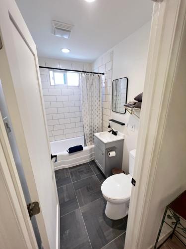 een badkamer met een toilet, een wastafel en een bad bij Little Betty's Casita in Torrance