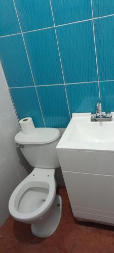 a bathroom with a white toilet and a sink at Bonito y práctico departamento. in Ixmiquilpan