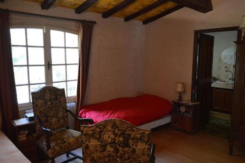 - une chambre avec un lit rouge et une fenêtre dans l'établissement Maison provençale traditionnelle avec air conditionné, à Saint-Raphaël