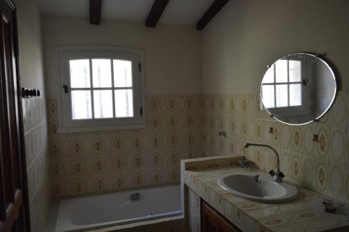 une salle de bain avec un lavabo, un miroir et une baignoire dans l'établissement Maison provençale traditionnelle avec air conditionné, à Saint-Raphaël