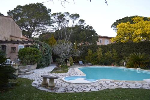 - une piscine dans une cour entourée d'une passerelle en pierre dans l'établissement Maison provençale traditionnelle avec air conditionné, à Saint-Raphaël