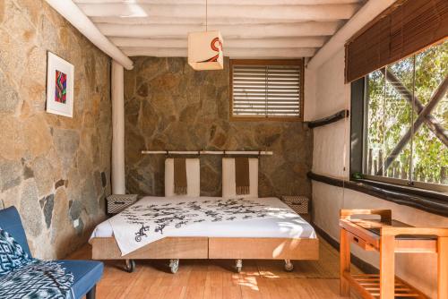 a bedroom with a bed in a stone wall at Las Cabañas de Tarii in Cieneguilla