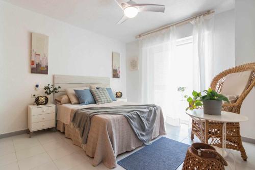 1 dormitorio con cama, mesa y ventana en Kuthana Rentals Duplex Copacabana en primera línea, en La Manga del Mar Menor