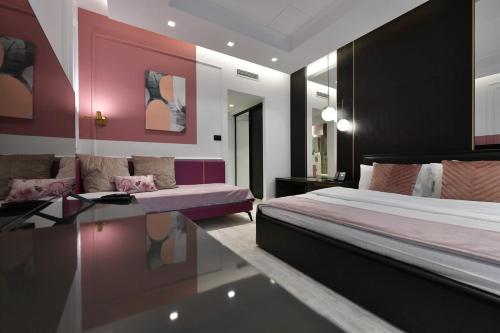 a bedroom with a bed and a couch and a table at Royal Wellness and Spa in Ruma