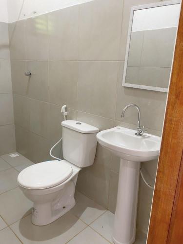 uma casa de banho com um WC e um lavatório em Chalé Duplo em Pacoti