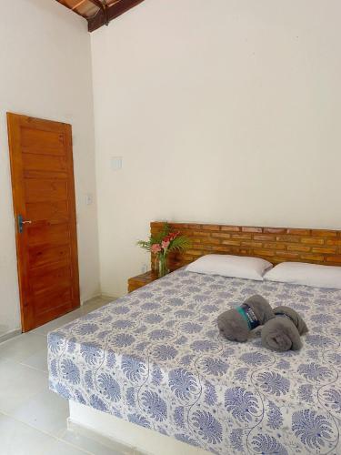 um bicho de peluche deitado numa cama num quarto em Chalé Duplo em Pacoti