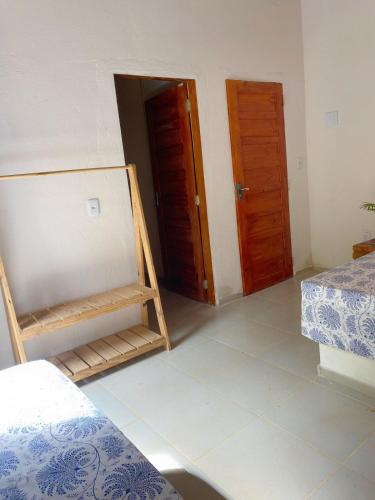 um quarto com duas camas e duas portas de madeira em Chalé Duplo em Pacoti