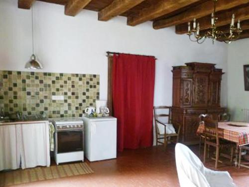 a kitchen with a red curtain and a table at Gîte Le Tremblay in Thianges