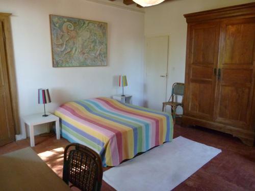 Thiangesにあるジット ル トランブレイのベッドルーム1室(カラフルな毛布付きのベッド1台付)