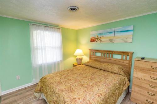 a bedroom with a bed and a dresser and a window at Myrtle Beach Fun Vacation in Myrtle Beach