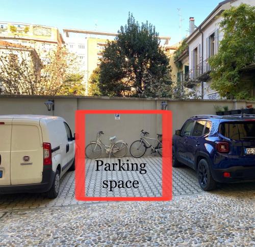 a parking space sign in front of two cars at Milano Central in Milan