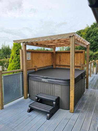 a gazebo with a hot tub on a deck at The Windsor Lodge in Ellesmere