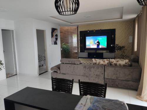 a living room with a couch and a flat screen tv at Casa Lenger in Aracaju