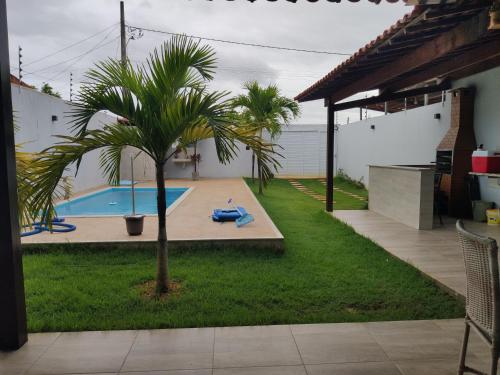 a palm tree in a yard with a swimming pool at Casa Lenger in Aracaju