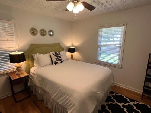 a bedroom with a white bed and two windows at Modern Athens Home 4bd, 3bth in Athens