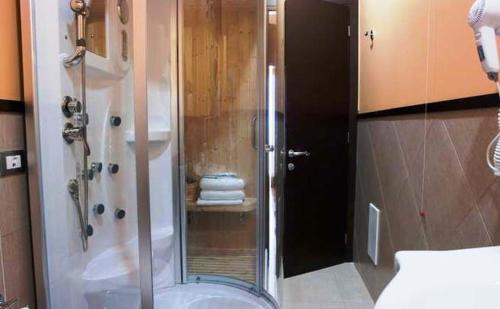 y baño con ducha y puerta de cristal. en Magicomar Hotel, en Ascea