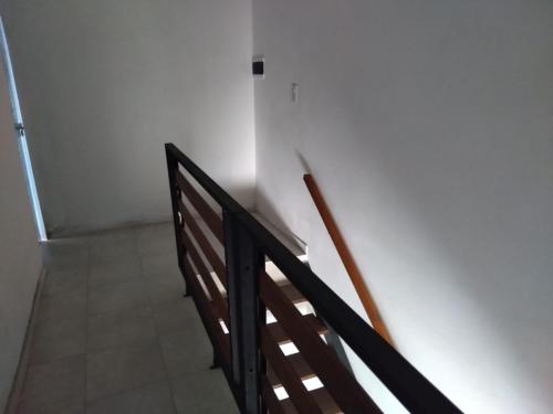 uma escada com um corrimão de madeira num quarto em Alojamiento Temporarios NEA em Formosa