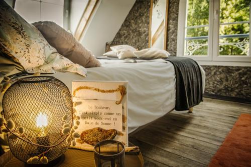 - un lit avec un livre sur une table à côté dans l'établissement La longère en Baie - au calme sur Saint Valery pour 4, à Saint-Valery-sur-Somme