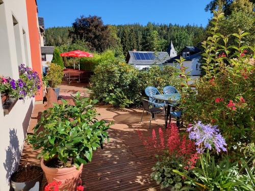 a patio with flowers and a table and chairs at Villa Helvetia in Bad Elster