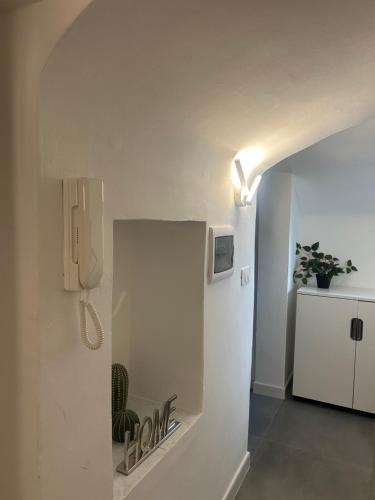 バーリにあるManzoni Suiteの冷蔵庫、壁掛け電話が備わる客室です。