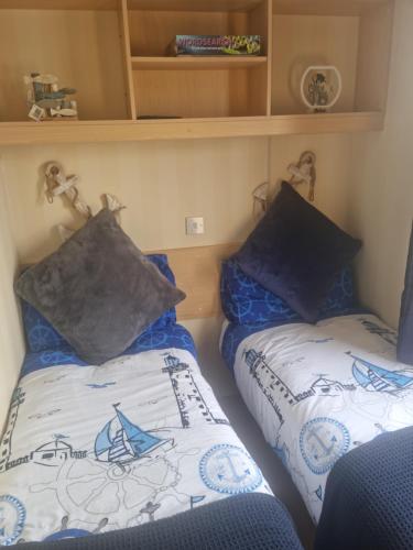 a bedroom with two beds in a small room at Serenity in Monreith
